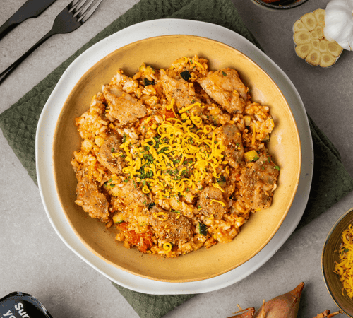 FuelYourBody tomatenrisotto met kip op een bord